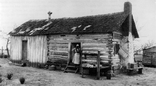 American slave woman standing in doorway of slave cabin